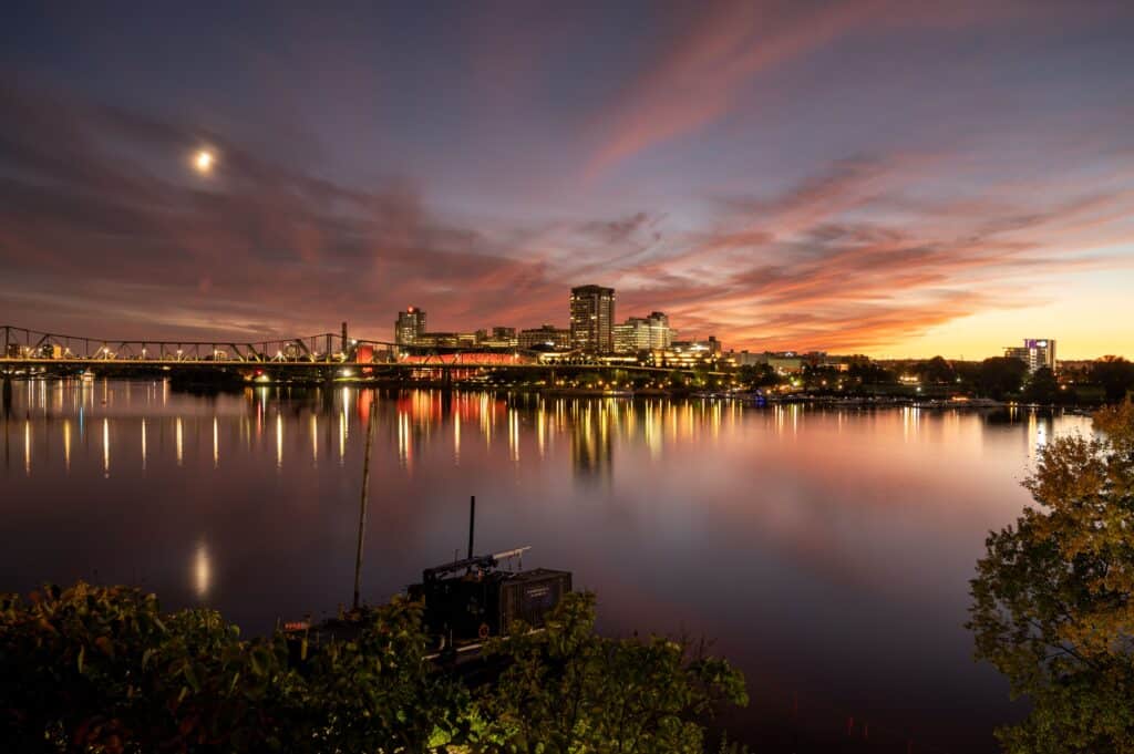 Reflections of city skyline and bridge over a calm river at sunset in Brisbane, Australia.
